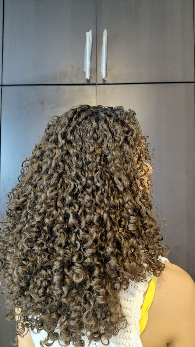 Cabello rizado definido y con brillo después de usar el elixir de coco Yoisé